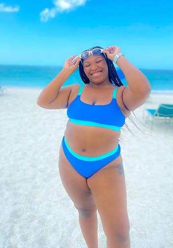 curvy reviewer wearing the suit with goggles on a beach