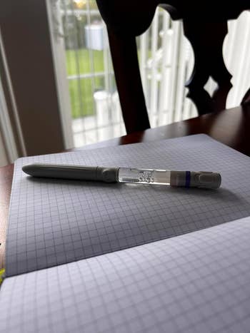 Gel pen placed connected  an unfastened  grid notebook connected  a woody  table, adjacent   a model   with a presumption    of writer  and trees. Ideal for penning  oregon  journaling