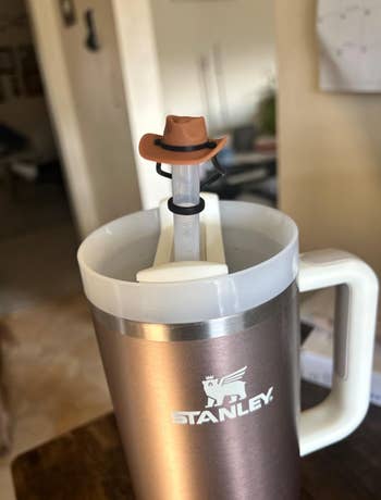brown cowboy hat straw topper on a reviewer's Stanley cup 