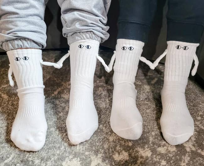 two pairs of socks connected reviewers holding hands