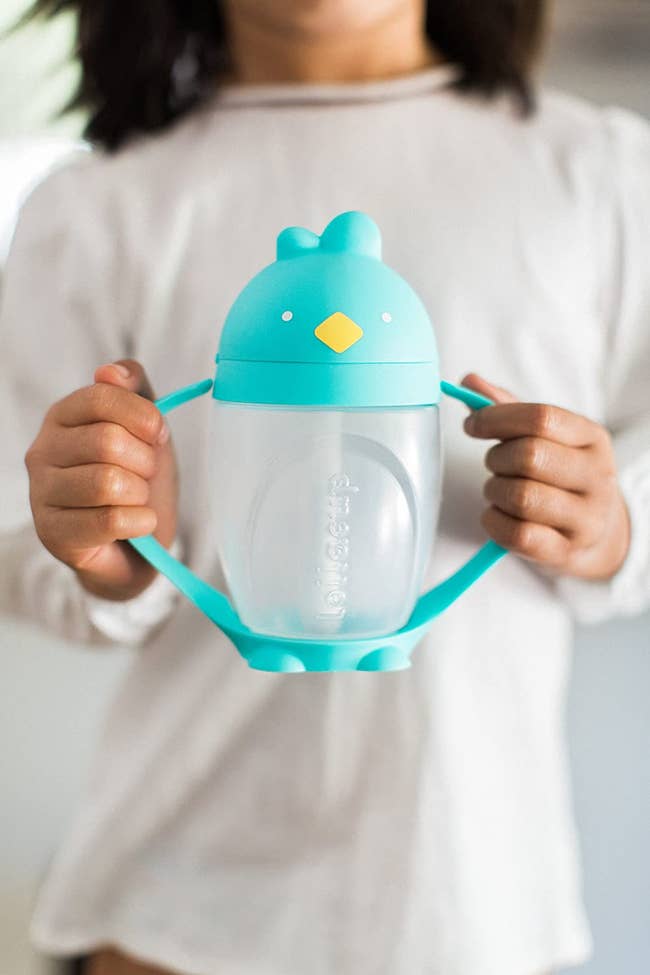 child holding a penguin-shaped sippy cup