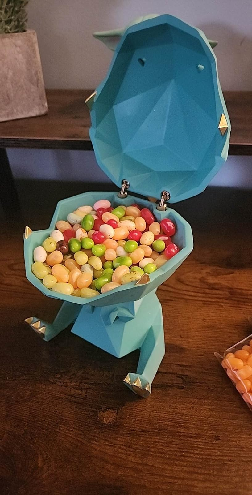 a reviewer photo of the same figurine with the mouth open revealing jelly beans inside 