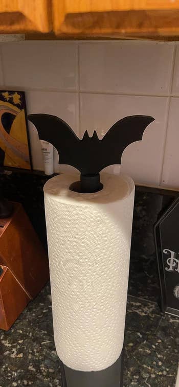 The bat paper towel holder with a roll of paper towel on a reviewer's countertop 
