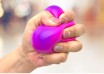 Model squishing a pink ball until it's purple 
