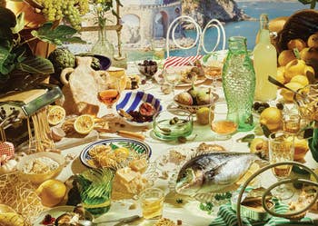 A Mediterranean-themed array with seafood, olives, pasta, lemons, glassware, and decorative plates, acceptable against a coastal backdrop