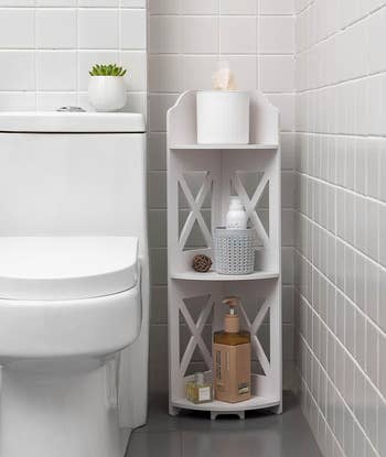 white corner shelf with toiletries and decorative items between toilet and wall