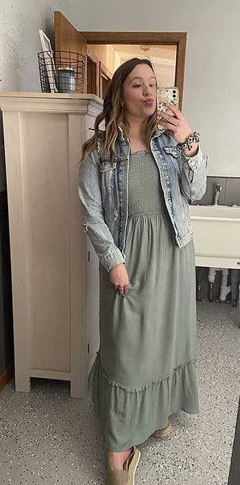 reviewer in green maxi dress and light wash denim jacket