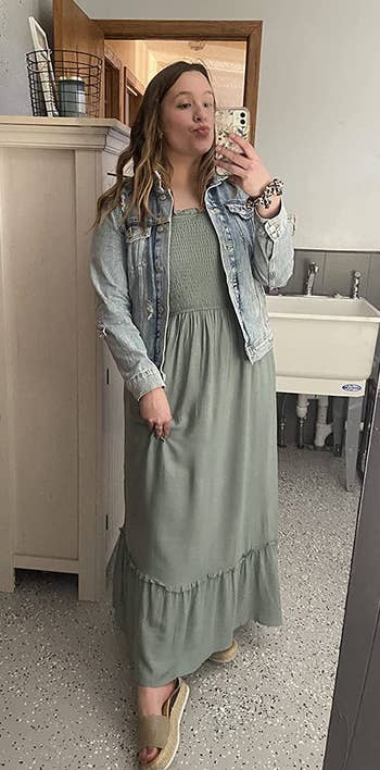 reviewer in green maxi dress and light wash denim jacket