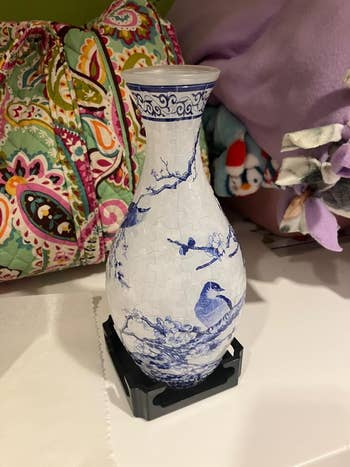 A reviewer's white vase with blue bird and branch design