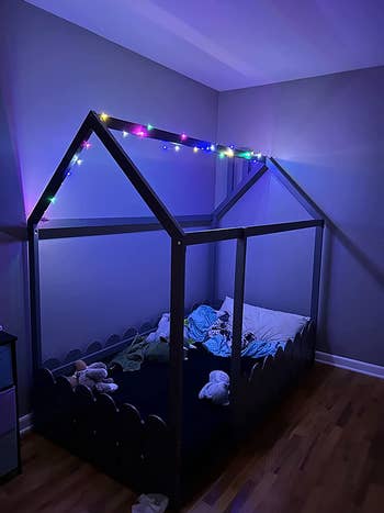 the rainbow lights wrapped around a reviewer's son's bed