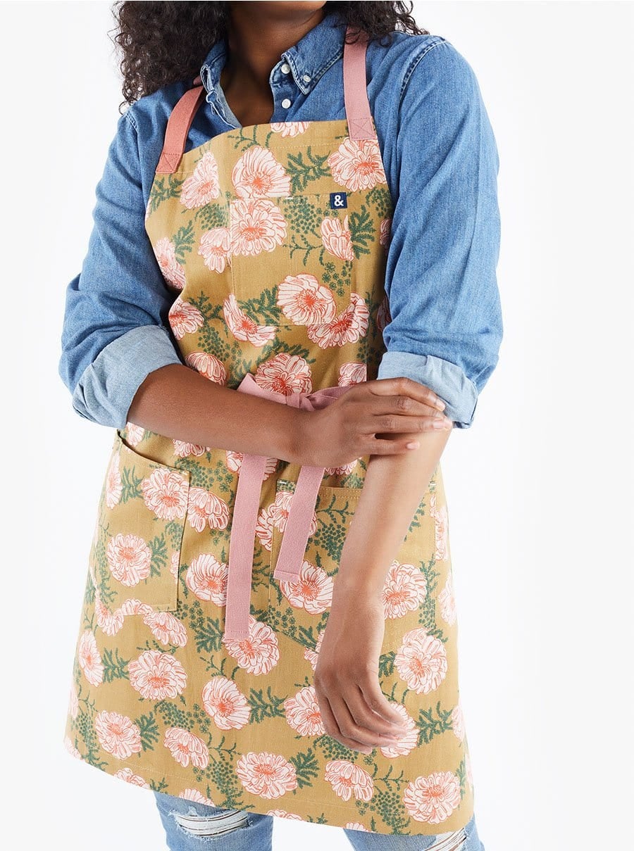 model wearing the yellow flower print apron