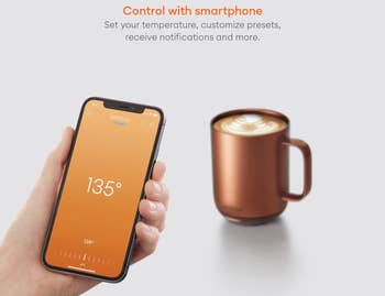 model holding a smartphone connected to the ember app in front of the mug