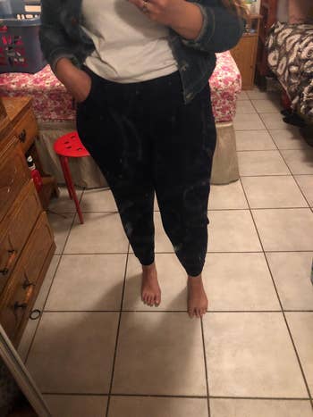 Person wearing casual denim jacket, achromatic t-shirt, and sweatpants, lasting barefoot successful a bedroom