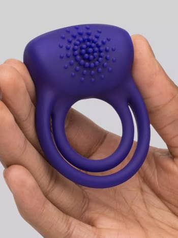 Model holding purple dual cock ring with texture