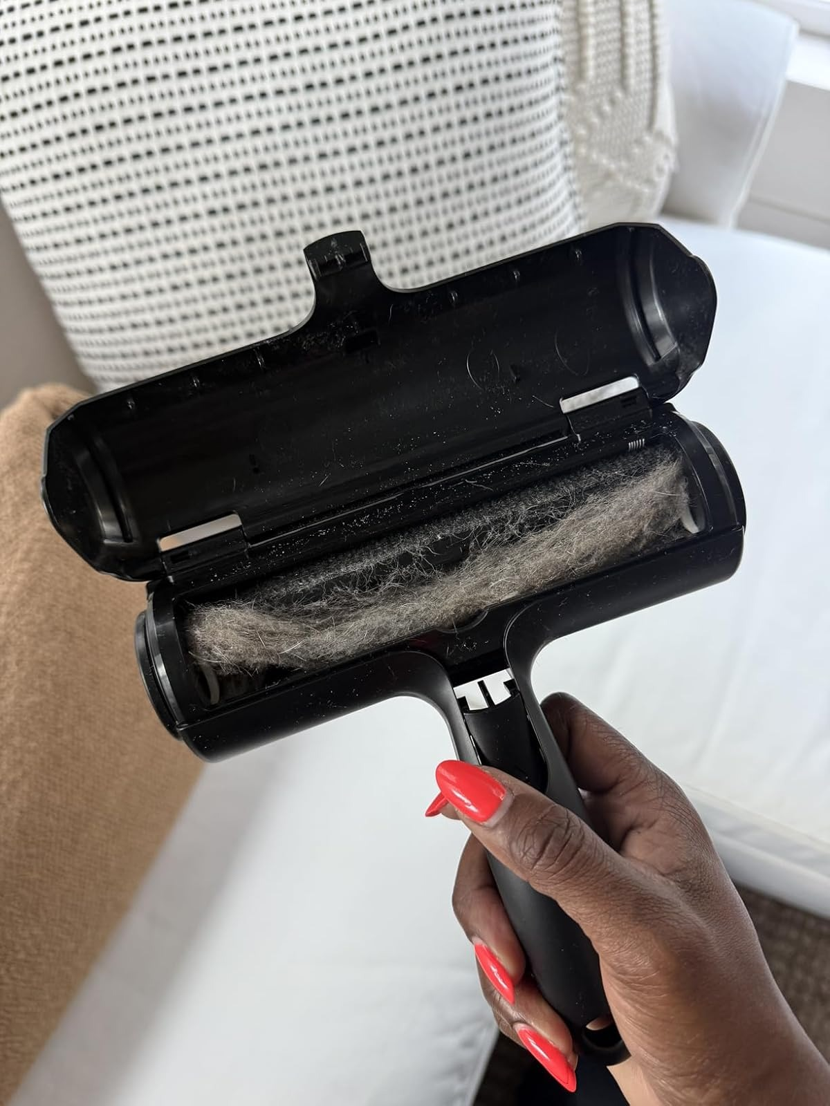 Hand holding a lint roller filled with fur, positioned implicit    a sofa, illustrating effectual  favored  hairsbreadth  removal