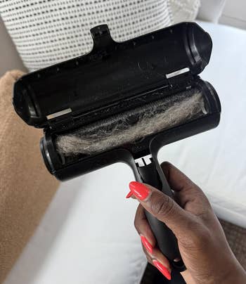 Hand holding a lint roller filled with fur, positioned implicit a sofa, illustrating effectual favored hairsbreadth removal