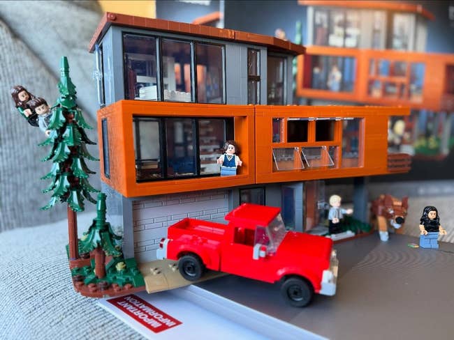Lego set featuring a modern house with a red truck, characters, and accessories, suitable for creative play and display