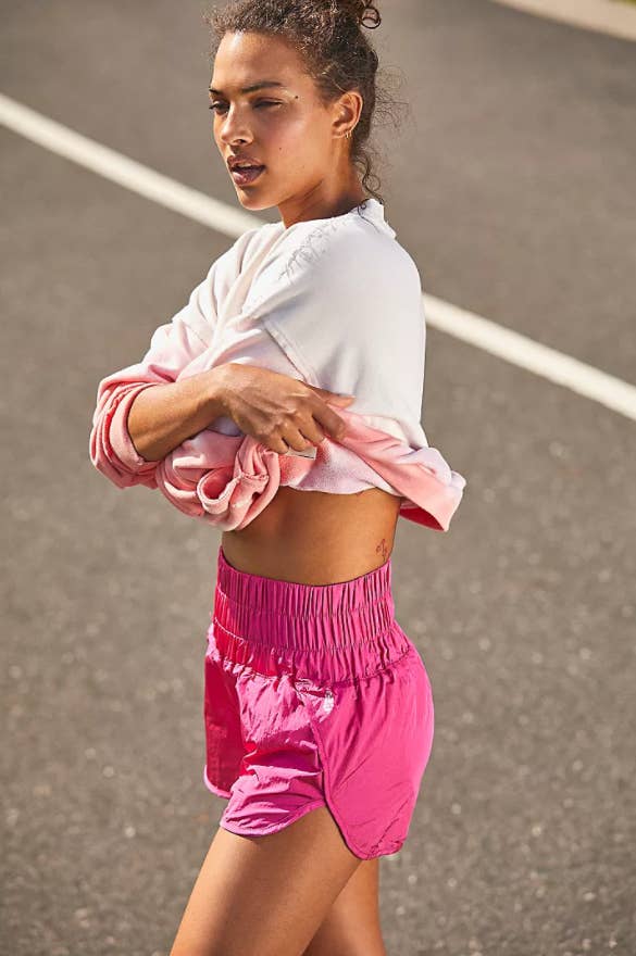 model wearing the high-waisted shorts in bright pink