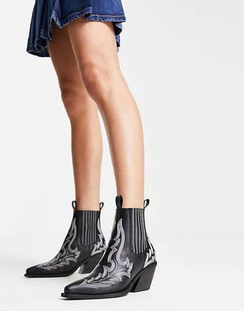 model in black pointy toe ankle boots with contrast stitching