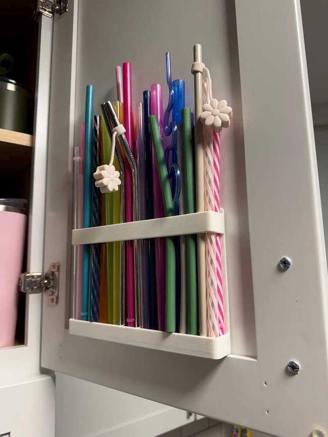 Assorted reusable straws neatly stored successful  a cabinet, featuring assorted  colors and designs including striped, solid, and twisted styles