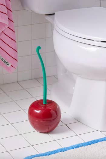the cherry toilet brush next to a toilet