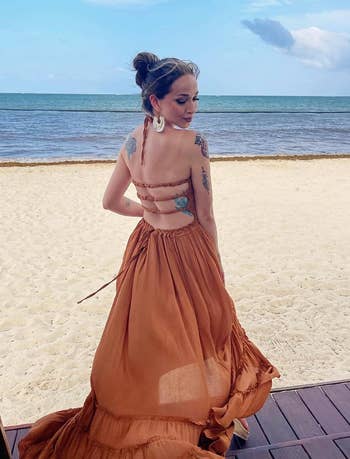 reviewer showing off the back of the orange maxi dress