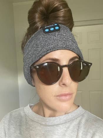 reviewer wearing the grey headphone headband with sunglasses 