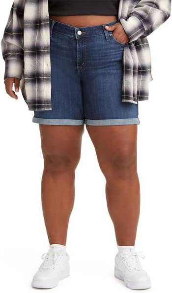 Model in plaid shirt and denim shorts