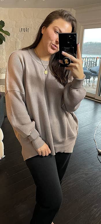 reviewer wearing the sweater in brown