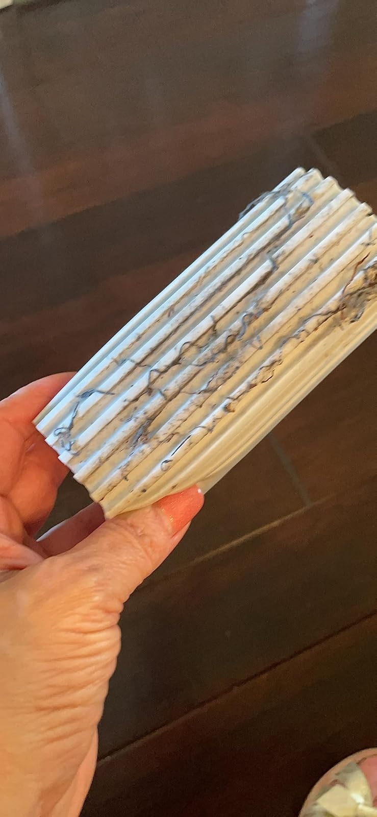 Person holding the duster sponge that is covered in dust and grime