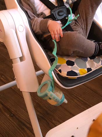 Child successful  a precocious   seat  holds a artifact  with a vessel  attached