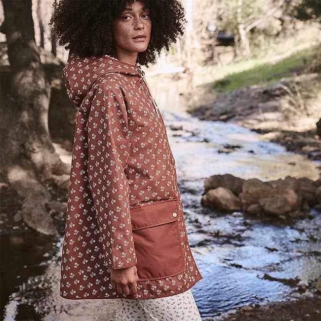 model wearing a brown floral rain jacket with large pockets