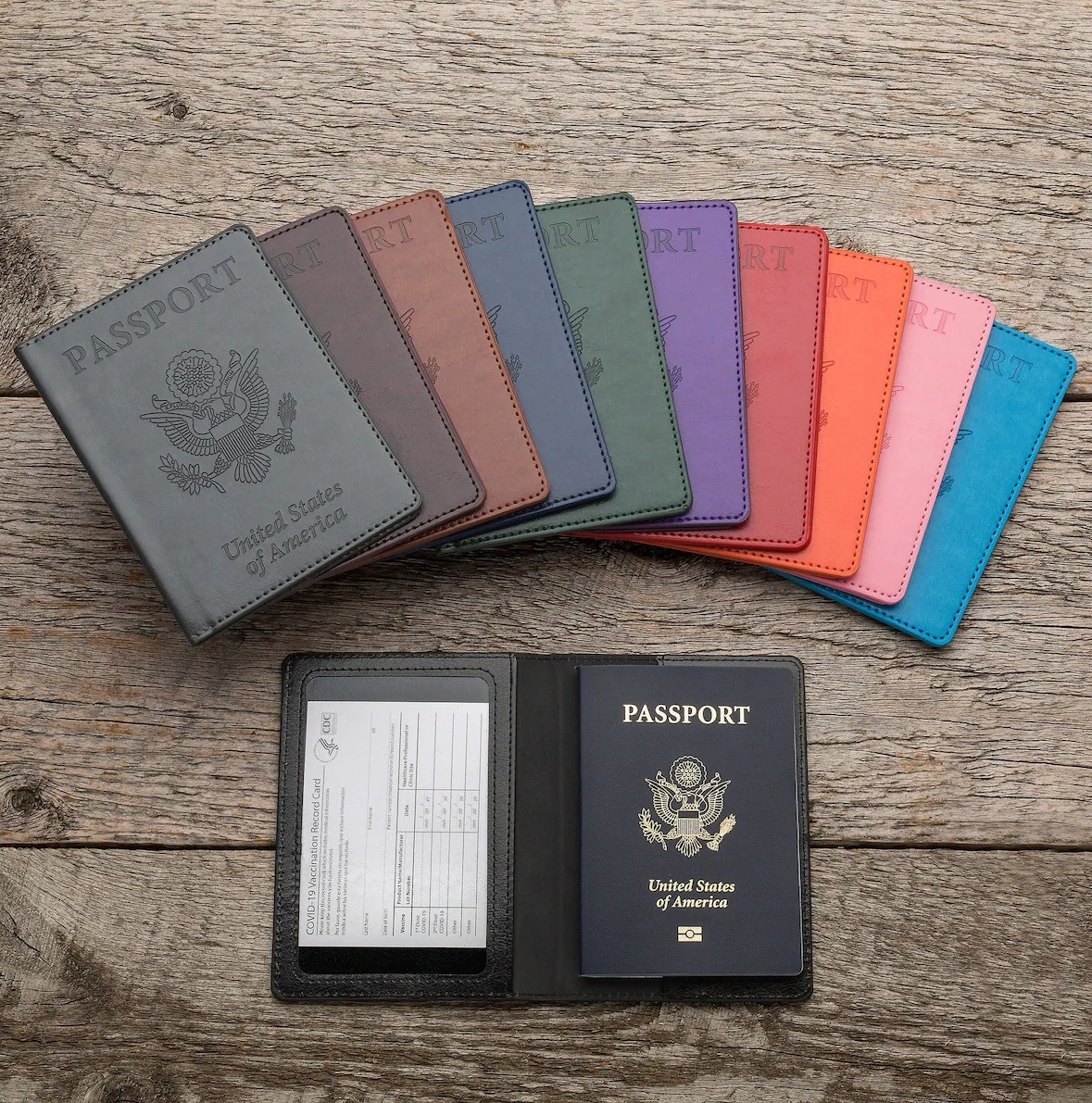 a vaccination card and passport in the black holder beneath fanned out holders in assorted colors 