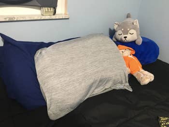 a different reviewer's gray cooling pillowcase on a bed