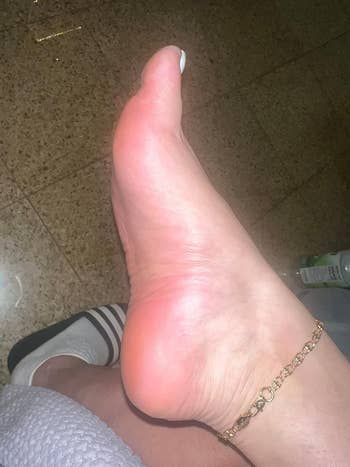 Bare ft  with  an anklet, resting connected  a tiled level  