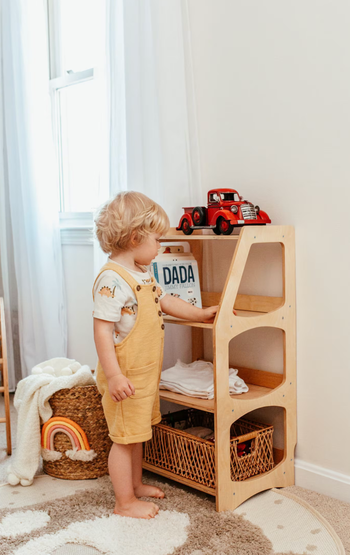 child reaching for something on a bookshelf