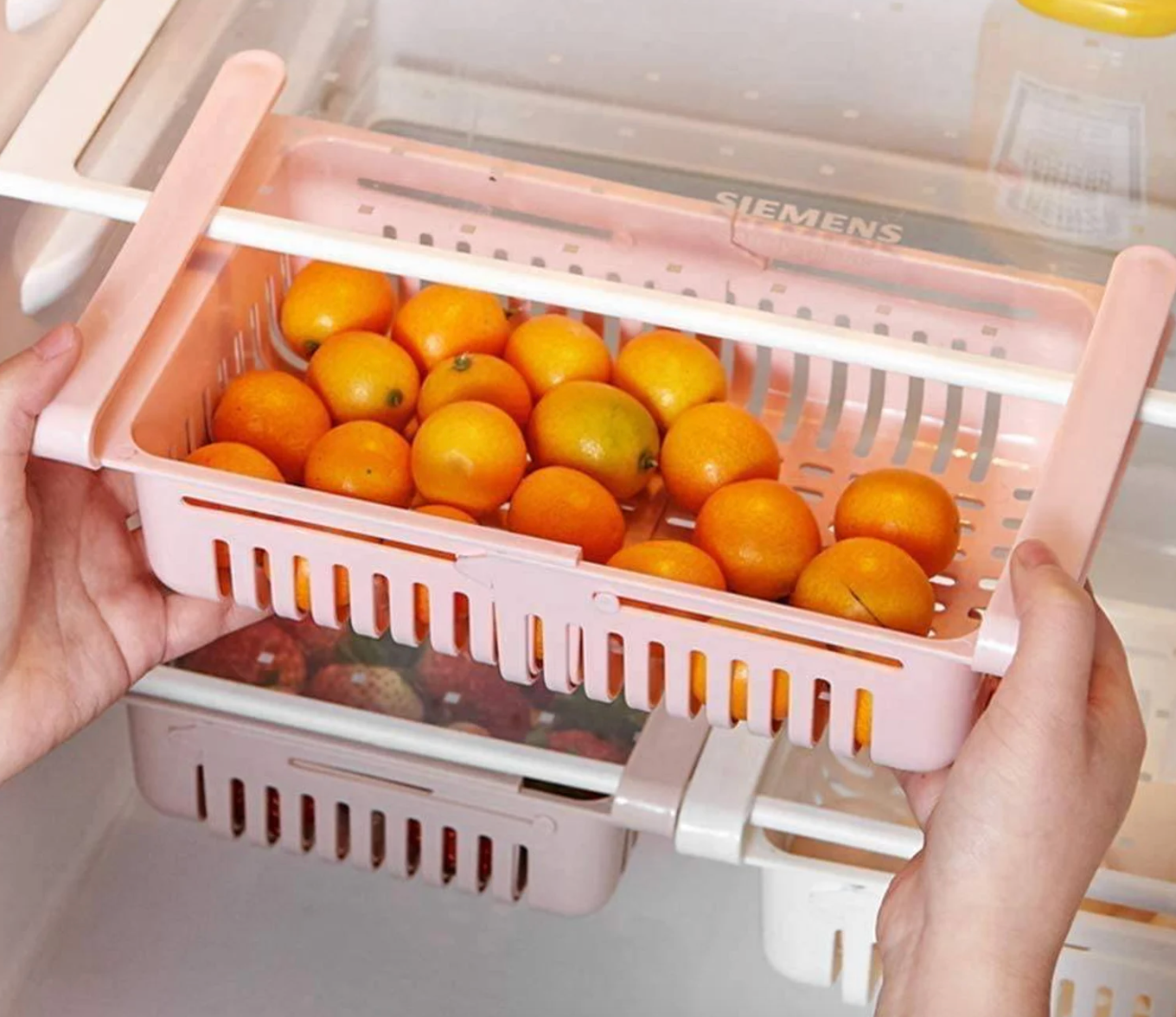 Model sliding a clip on pink drawer to a fridge shelf 