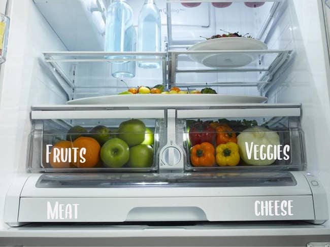 a fridge with white labels on its drawers reading fruits, veggies, meat, cheese respectively