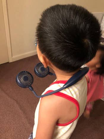 a child with the neck fan around their neck