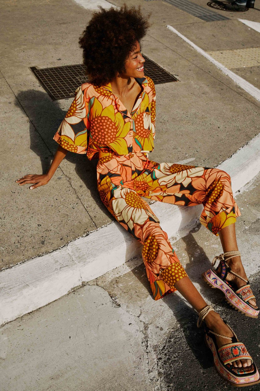 model posing on a sidewalk wearing the matching sunflower top and bottoms