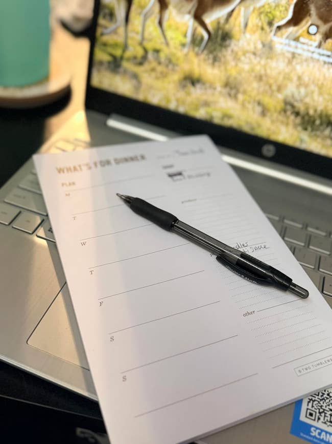 Dinner readying  notepad and pen connected  a laptop keyboard