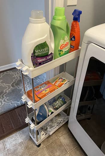 a reviewer photo of the cart pulled out and filled with laundry supplies 