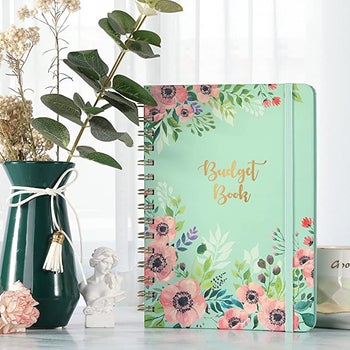 mint-color budget book with floral designs