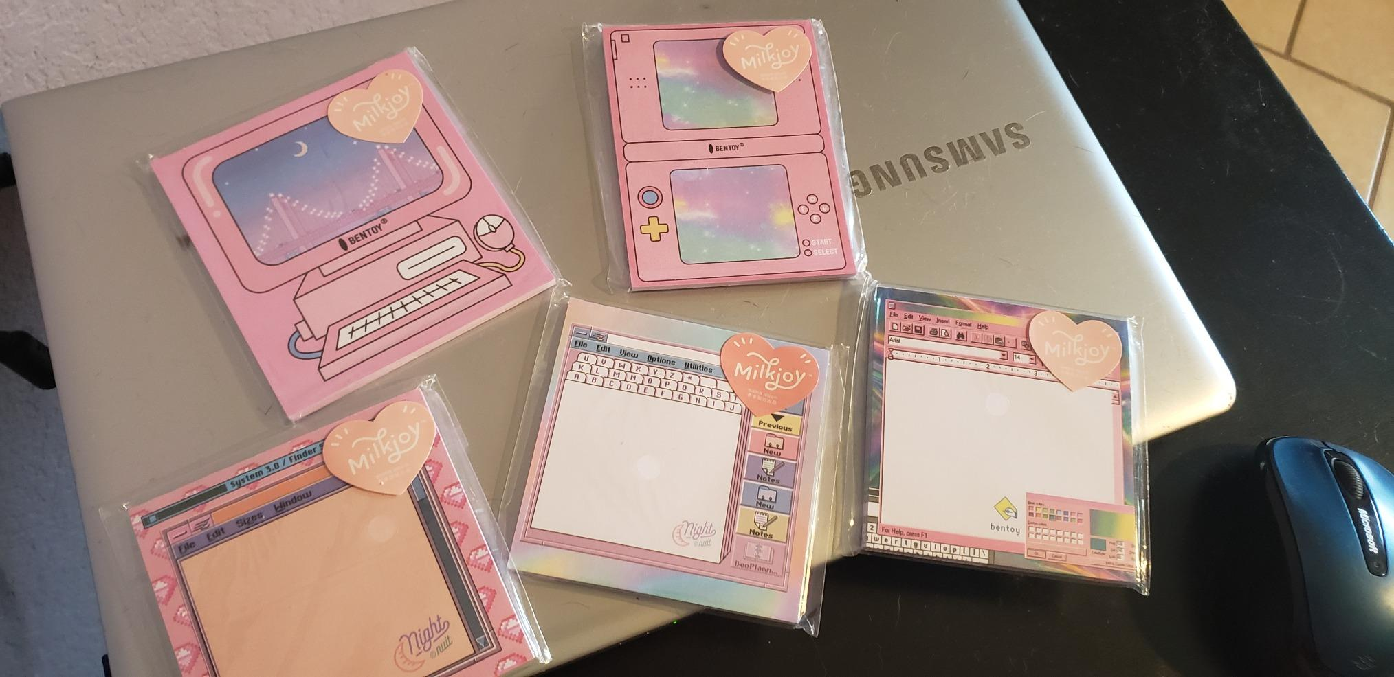 five of the sticky note packs on top of a laptop