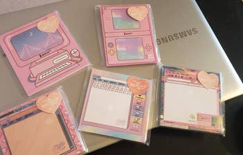 five of the sticky note packs on top of a laptop