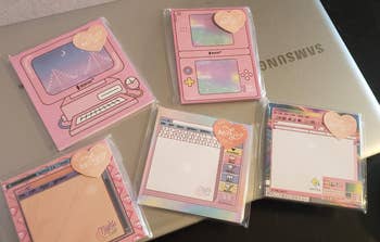 five of the sticky note packs on top of a laptop