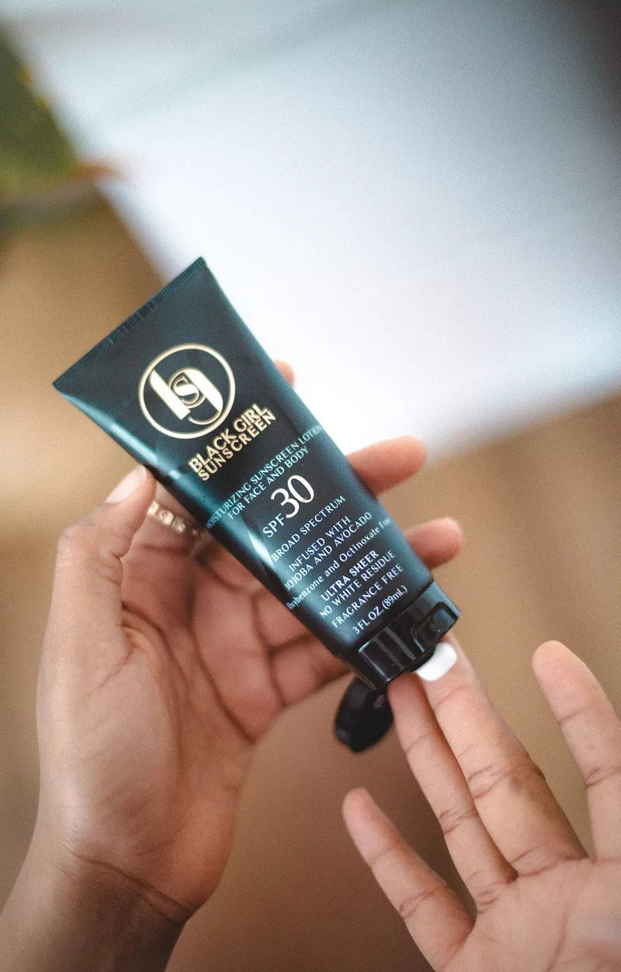 hand squirts tube of Black Girl Sunscreen