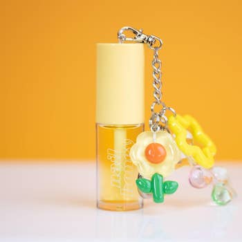 Nail polish instrumentality  with attached angiosperm  and bead charm against a coagulated  background, featured successful  a buying  article