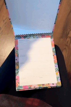 a gif of a floral desktop weekly planner being opened
