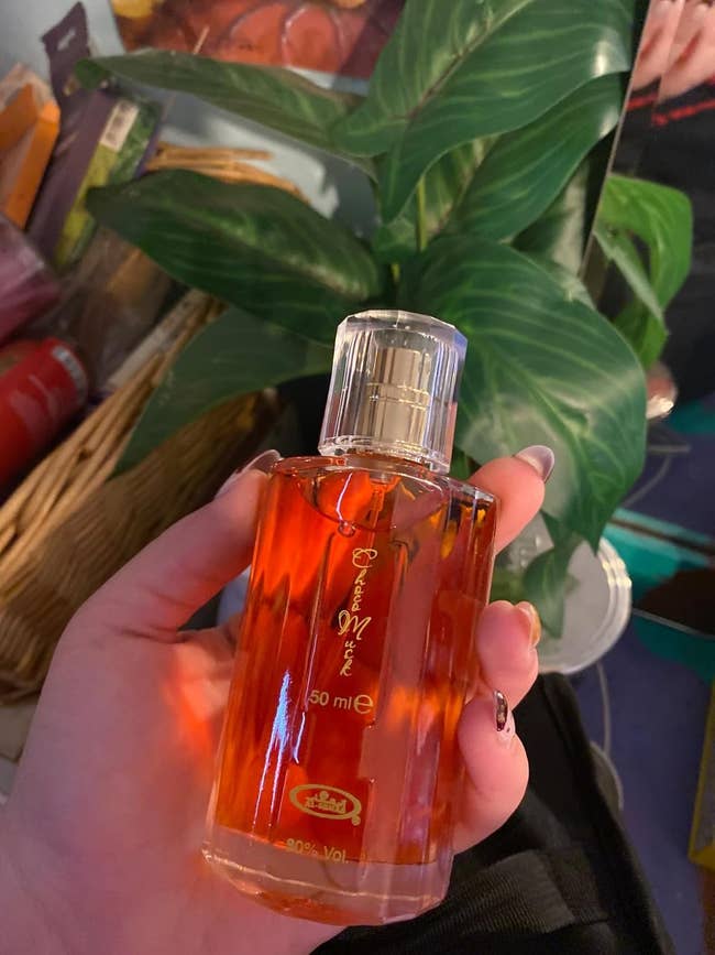 Person holding a vessel of perfume